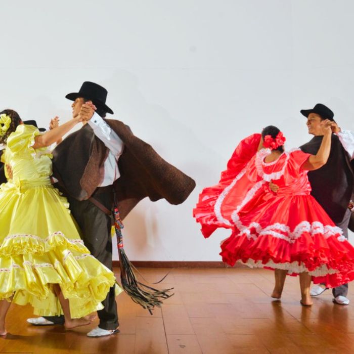 dos parejas de bailes andinos que se miran y sonrien