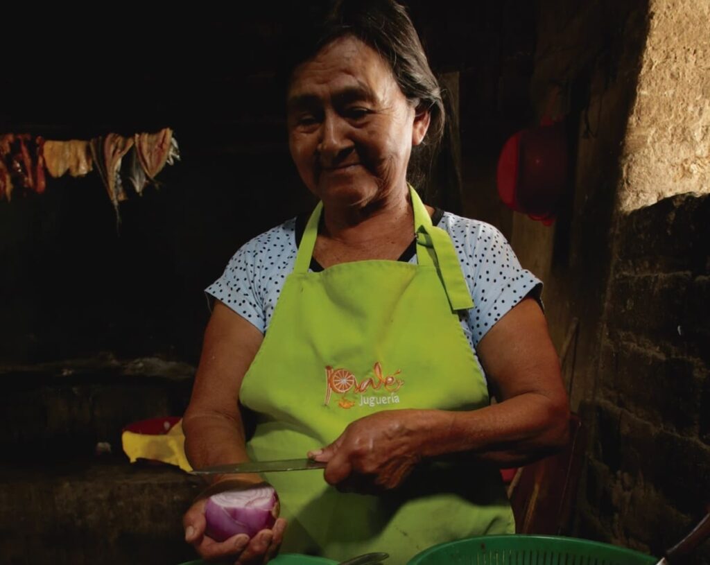 una señora esta en su una cocina tradicional resaltando el valor de la gastronomia tradicional