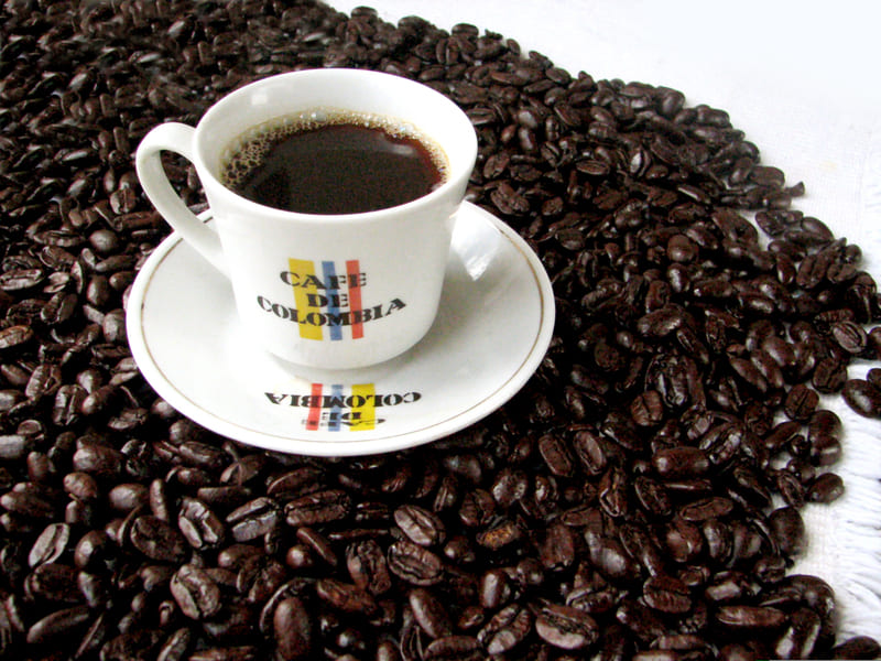 pocilo con cafe sobre granos de cafe de colombia