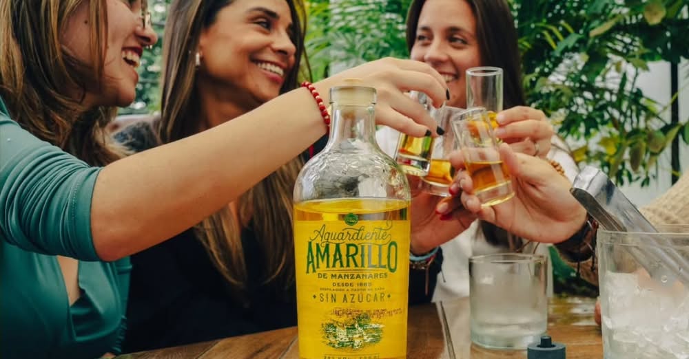 mujeres brindan con aguardiente amarillo